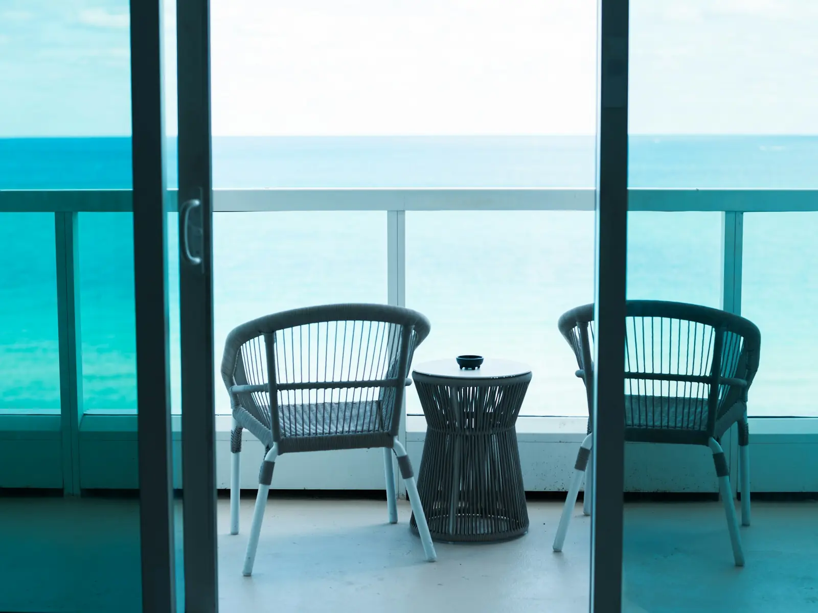 Two chairs on a hotel balcony overlooking the ocean